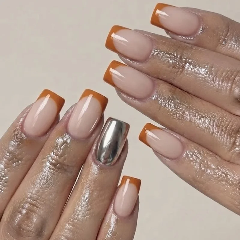 Chrome French tip nails new years eve manicure with a sheer nude base and a metallic chrome accent finger, up close view
