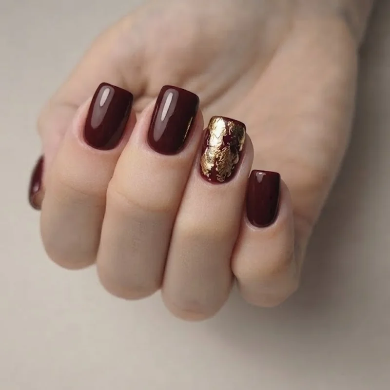 Gold foil accent nail over a dark burgundy base for an easy DIY NYE manicure look