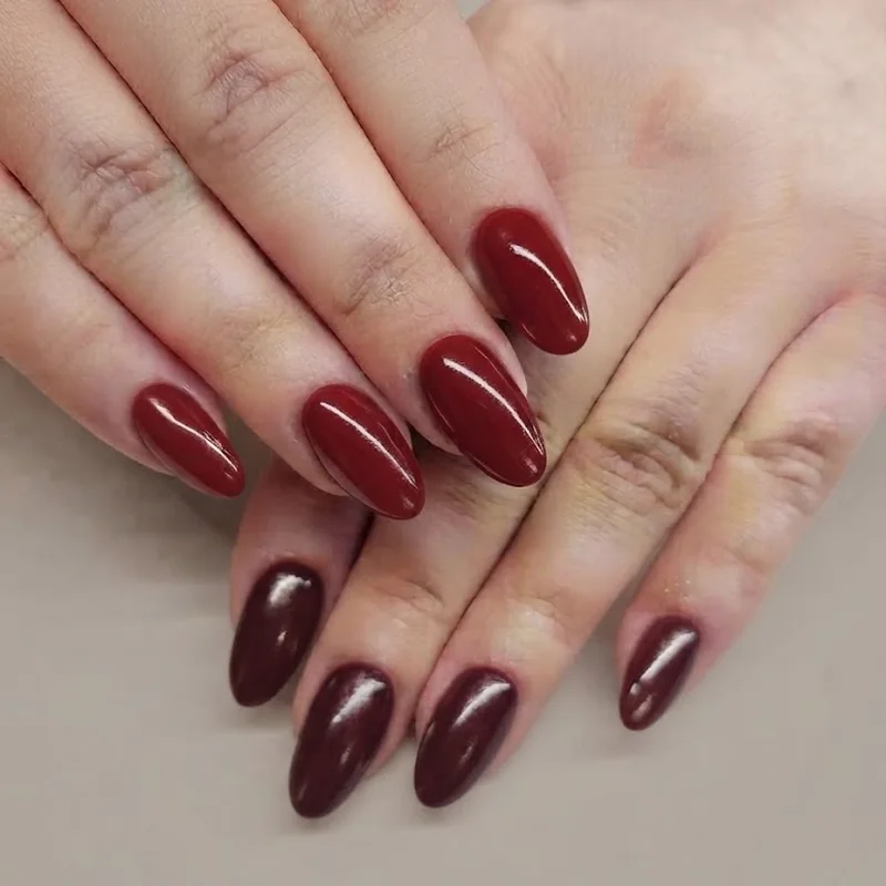 Cherry red and wine burgundy nail polish compared on two different skin tones