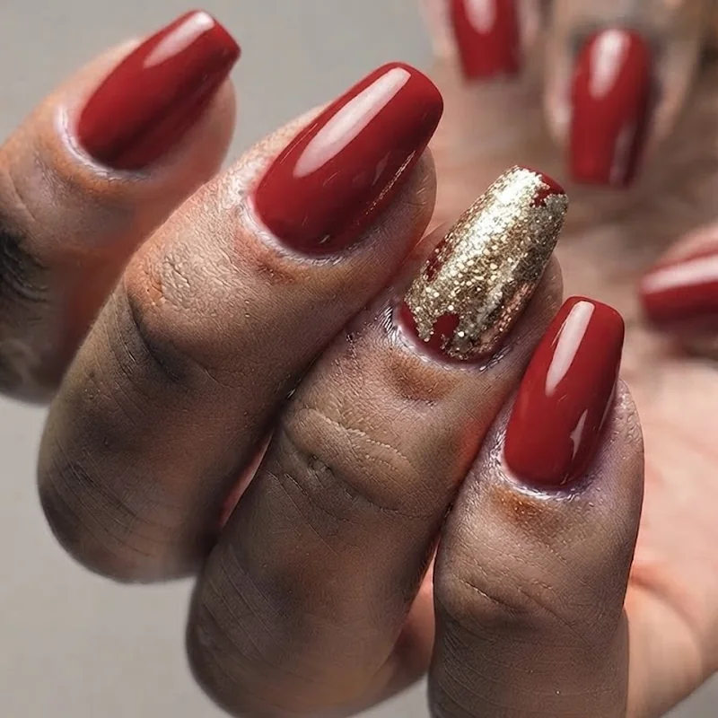Red nails with gold foil accent nail design for a luxe New Year