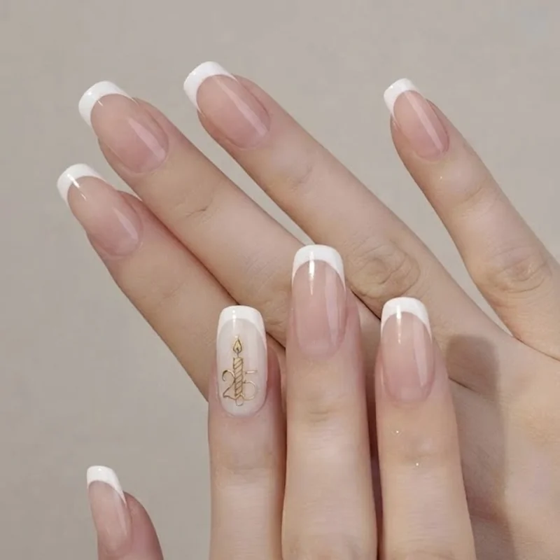 Gold linework birthday candle and number accent nail over a French tip October manicure