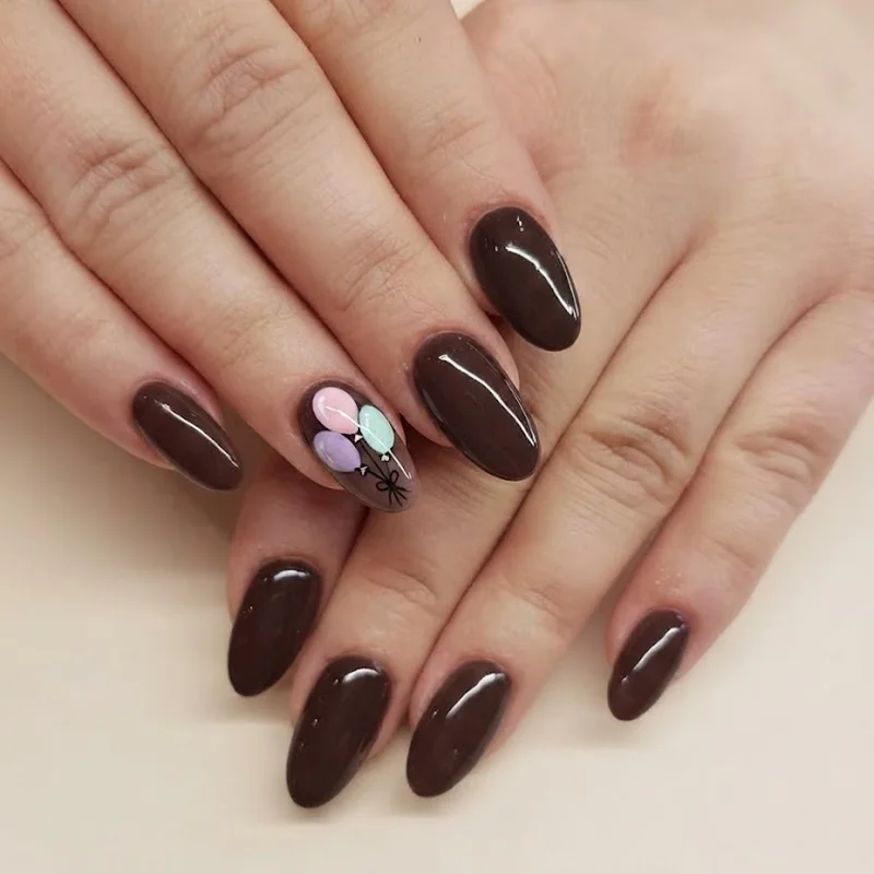 Pastel balloon accent nail on deep espresso base birthday manicure for October celebrations