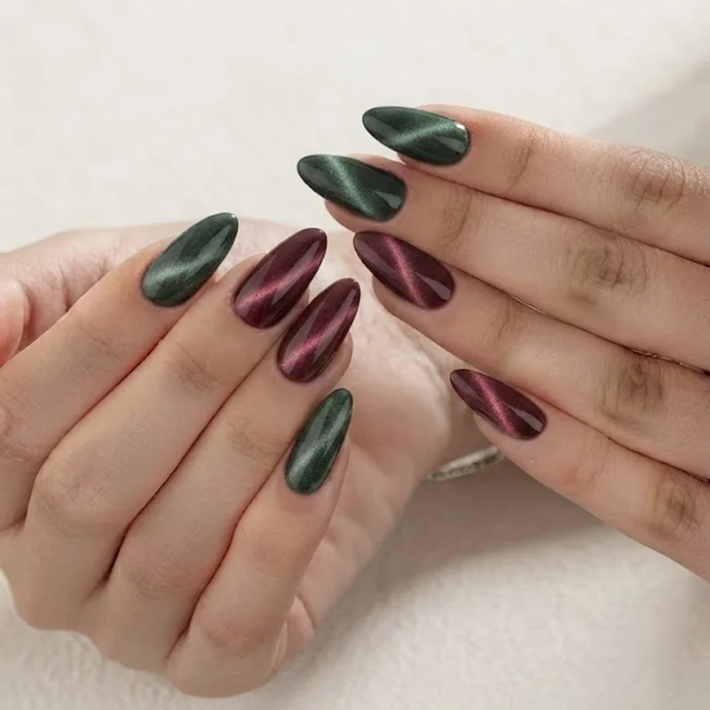 Deep cat eye nail art in burgundy on almond shaped nails showing magnetic finish