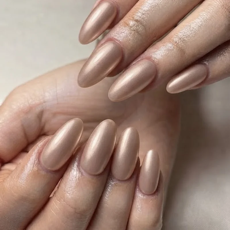 Soft chrome october nail trends manicure in champagne tone on neutral base nails