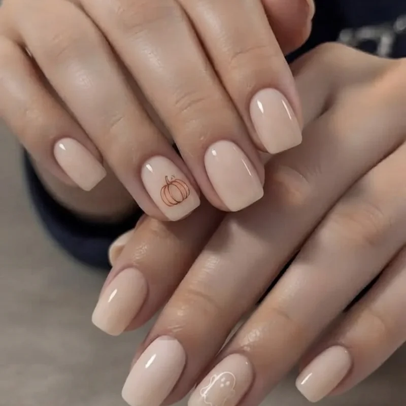 Short october nails with subtle pumpkin accent and ghost nail art on ring finger