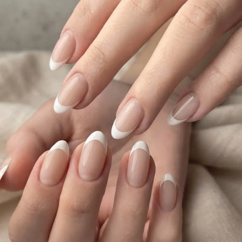 Classic white French tip design on oval nail shape showing the softened line at the tip curve