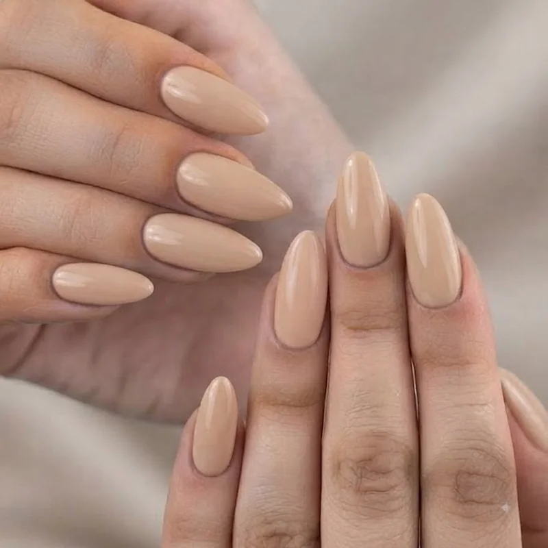 Close-up of oval vs round nails showing tapered tip on manicured hand with nude polish finish