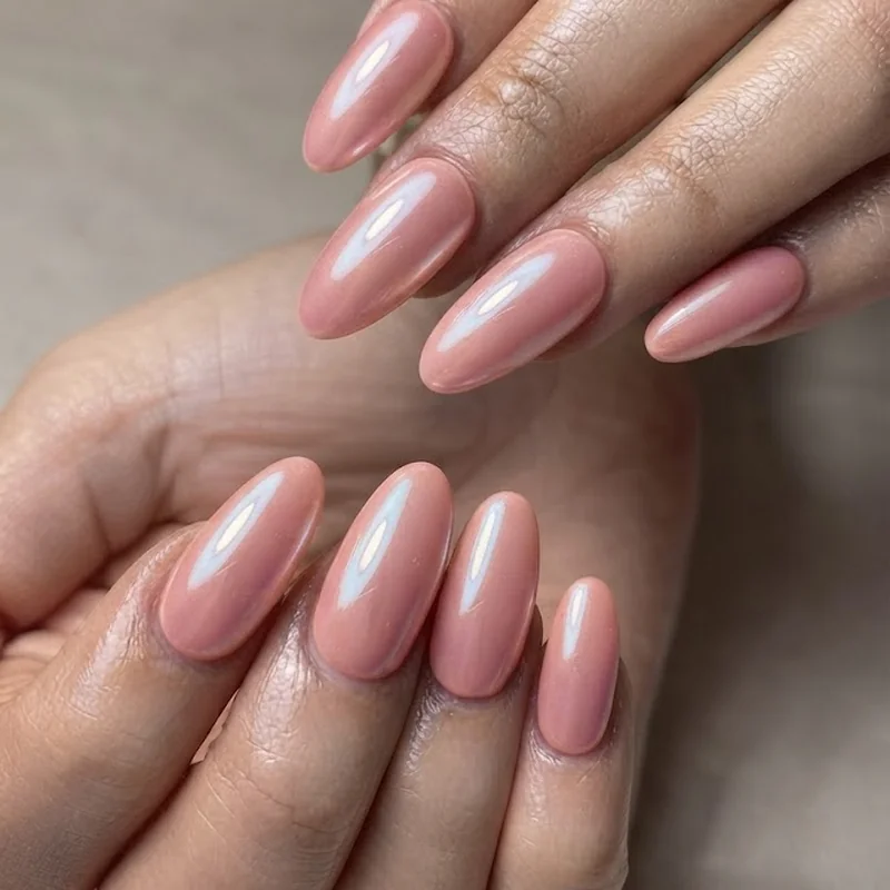 Colorful pink pearl statement nail design on an editorial nail shape with a glowing iridescent finish