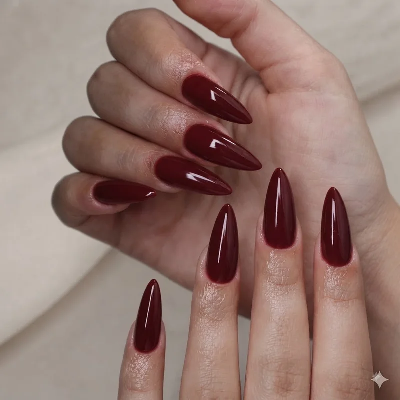 Glossy deep wine red manicure on almond shape nails for an evening date