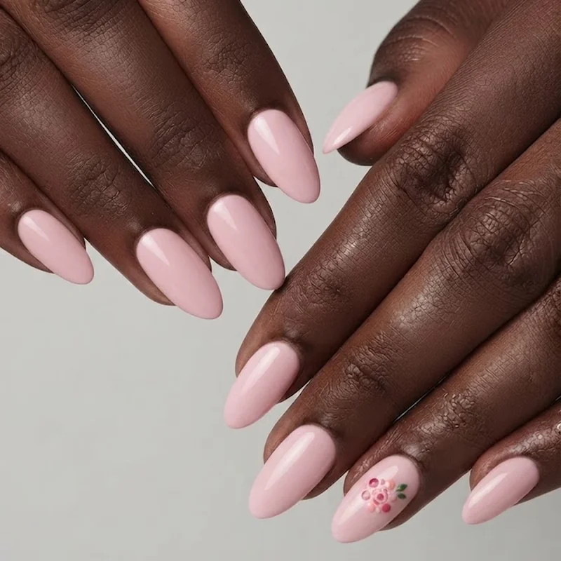 Almond shaped nails with small rose accent design near the cuticle in soft pink tones