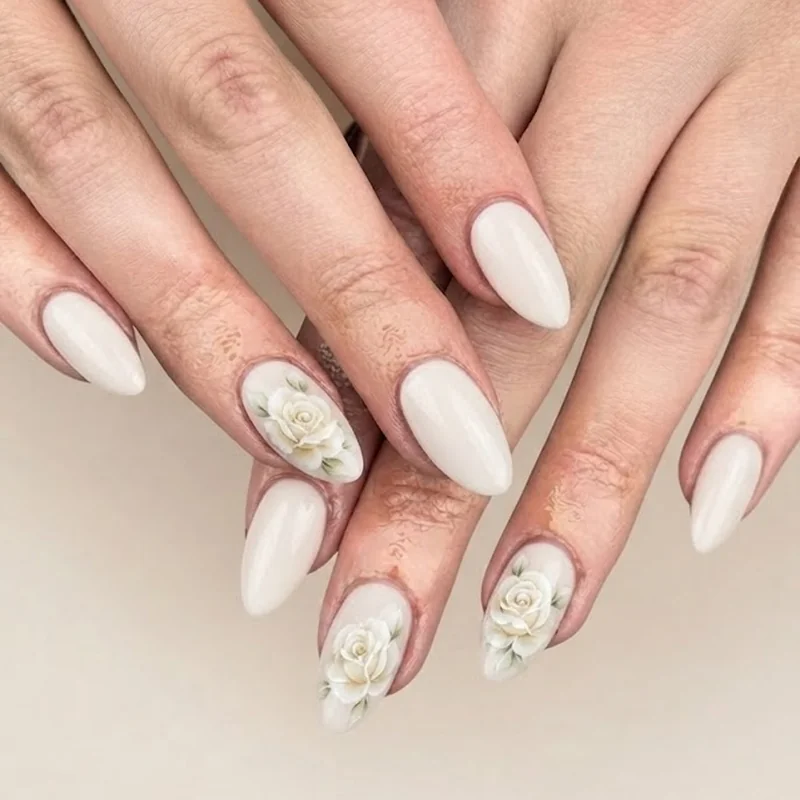 Elegant bridal rose nail design with delicate ivory roses on a soft white base manicure