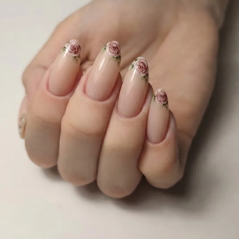 Rose motif french tip manicure with a tiny hand-painted bloom placed on the tip area