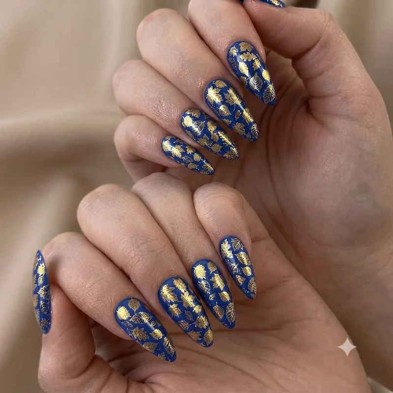 September birthday nails mood shot with sapphire blue polish and gold accent details on a manicured hand