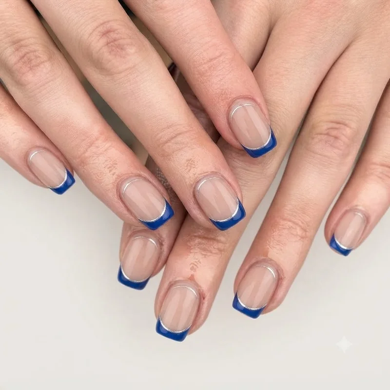 Short september birthday nails with sapphire blue french tip design on squoval nail shape