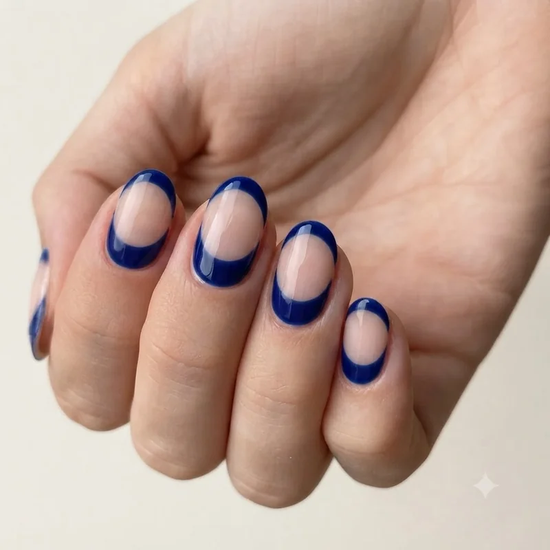 Sapphire negative space manicure with deep blue crescent at the cuticle on a bare nail bed