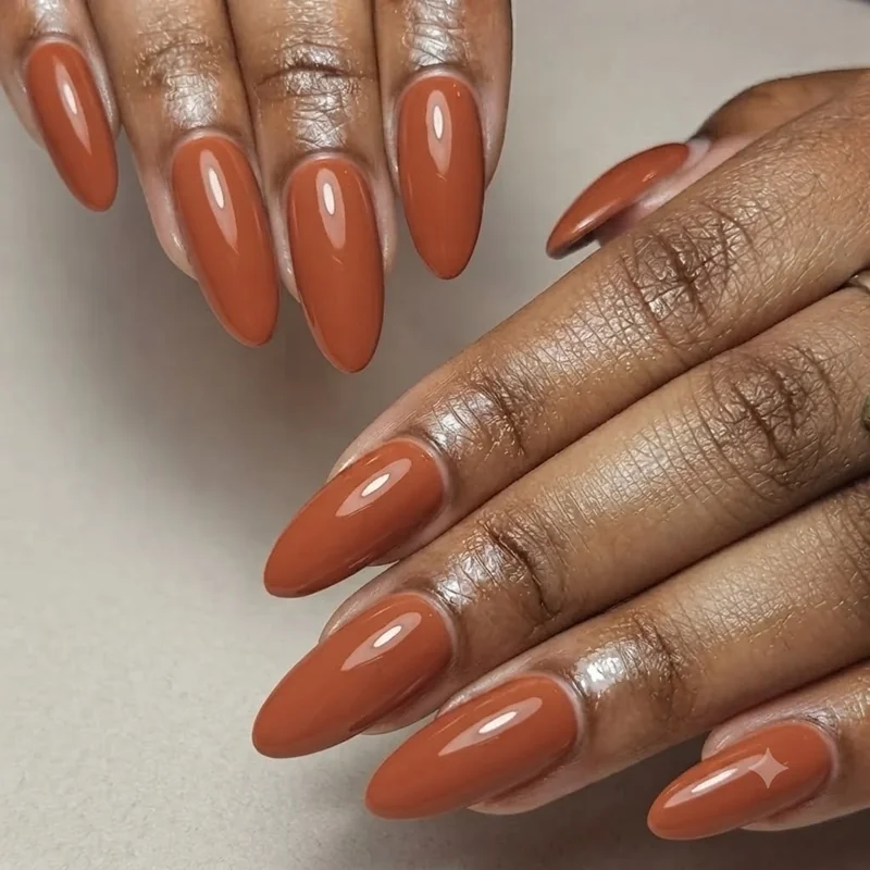 Early September nail color in warm terracotta shade on almond-shaped nails, a transitional look between summer and autumn