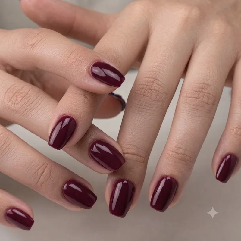 Late September nail color in deep burgundy jewel tone on coffin-shaped nails for a full autumn shift