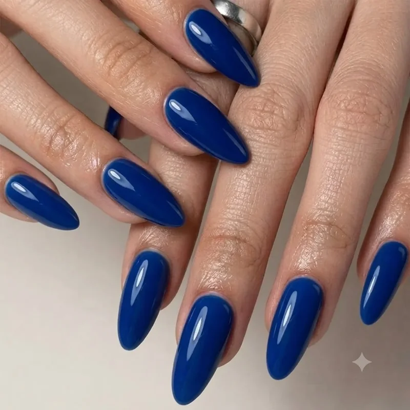 Sapphire blue jewel tone manicure shown as a late September alternative to burgundy nail colour this season