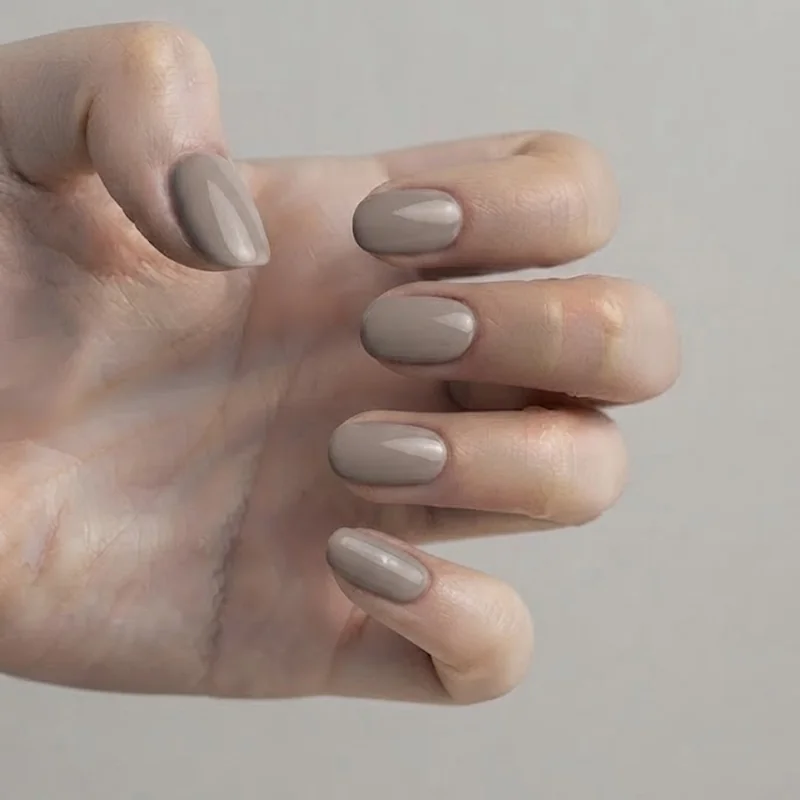 Short oval and round nail shapes styled together in a soft neutral fall polish shade for low-effort everyday manicure wear