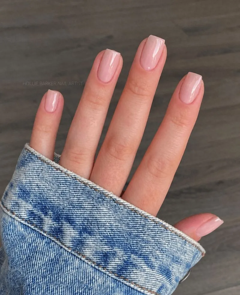 Quiet luxury minimalist manicure spring 2026 showing clean girl aesthetic with sheer nude polish and natural nail finish on oval