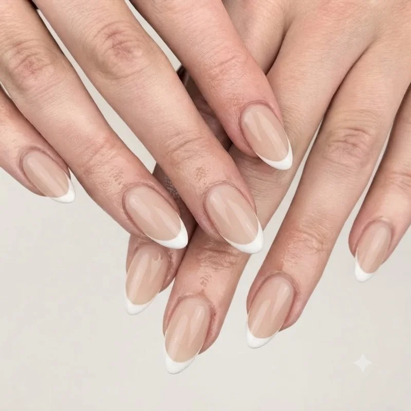 Classic white French tip over a sheer nude base on almond shaped nails with glossy finish