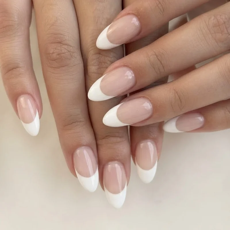 Close up of a simple french tip design in classic white on natural length nails