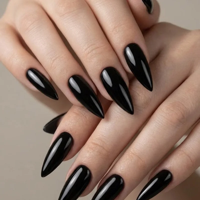 Long dramatic stiletto nail set in glossy black for a strong Halloween editorial finish