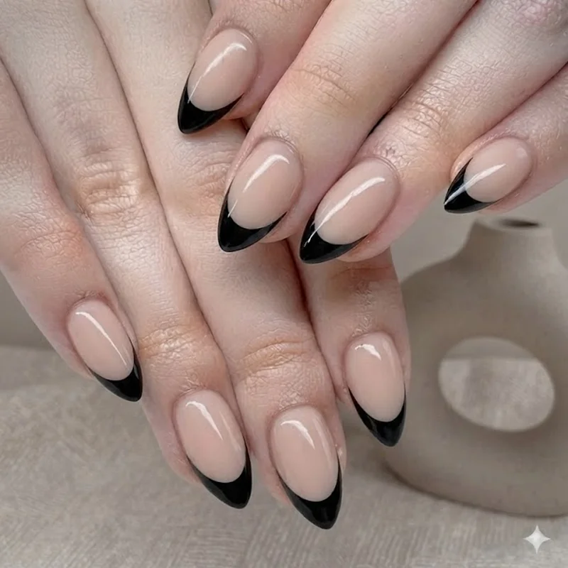 Glossy black french tip on nude base stiletto nails with high contrast finish