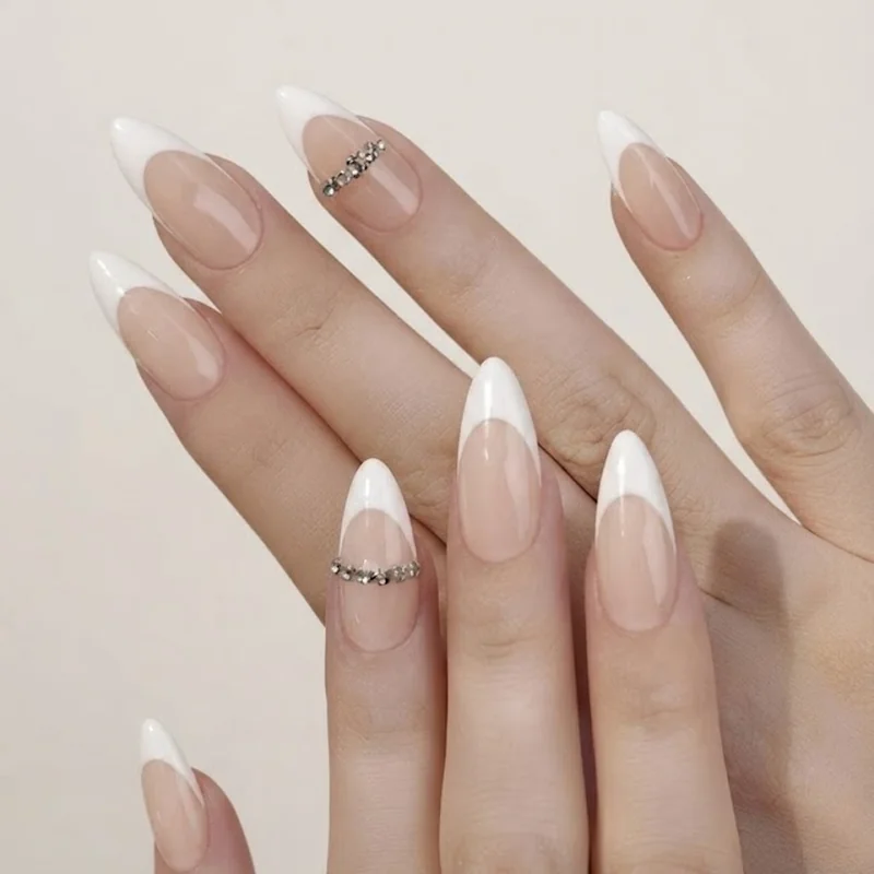 Finished stiletto french tip nail set styled with jewelry in aspirational lifestyle shot