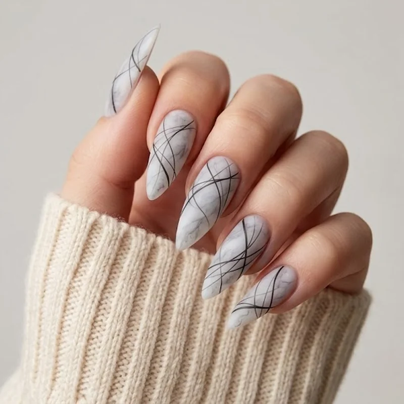 Mini stiletto nails on visibly natural-length nails in a glossy neutral finish for beginners
