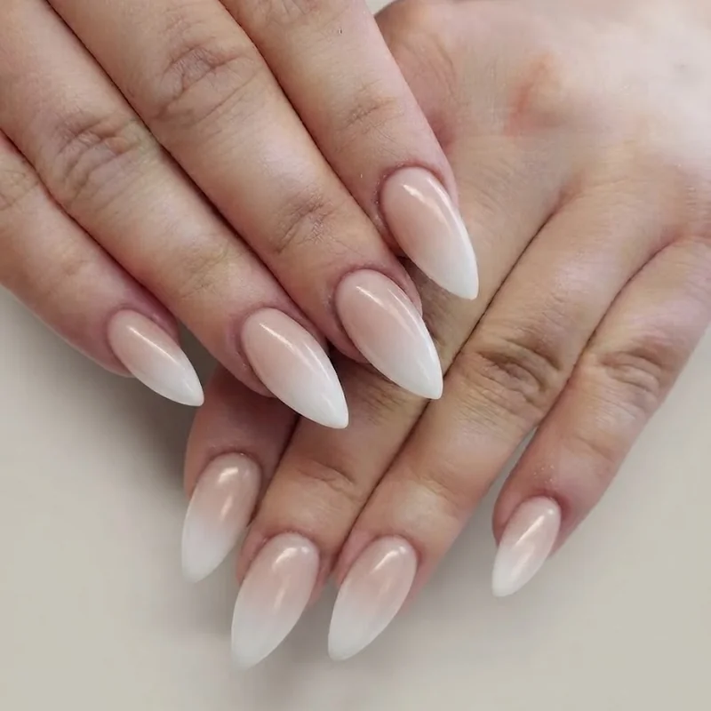 Milky white pearl stiletto nails with soft opalescent shimmer finish for a bridal manicure