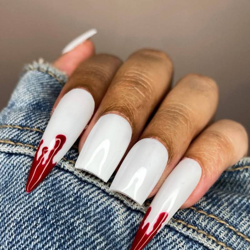 Stiletto vampire nails with fang accents and red polish