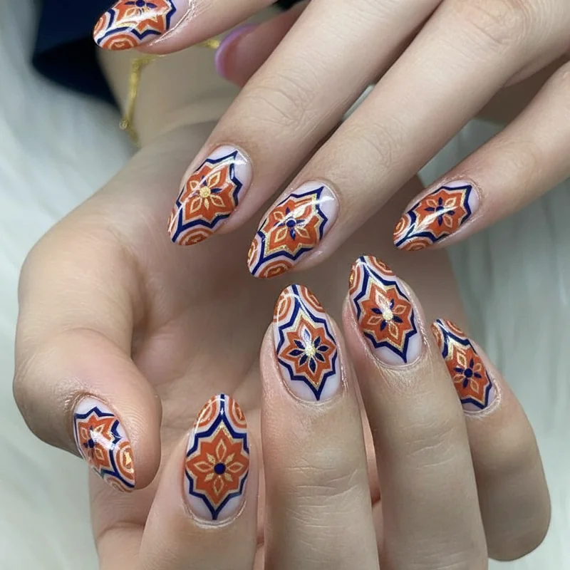 Mediterranean tile nail art in terracotta navy and sage with gold liner detailing showing repeating geometric diamond patterns on almond nails