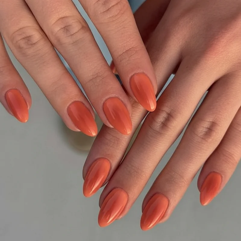 Nail polish colours for olive skin tone summer manicure featuring warm coral terracotta and persimmon orange shades on hand swatch
