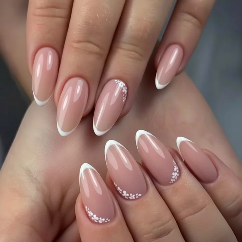 Floral micro French tip wedding nails with hand painted petals placed along the smile line on a sheer base gel bridal nails