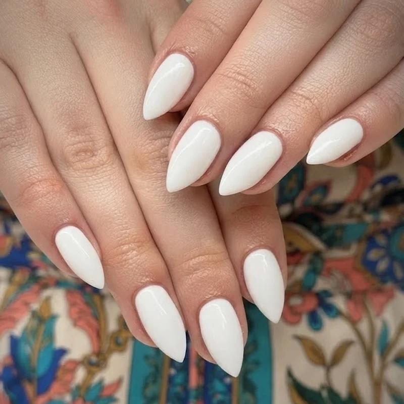 White nails wedding guest manicure paired with a colorful patterned outfit detail showing the nails versus dress distinction