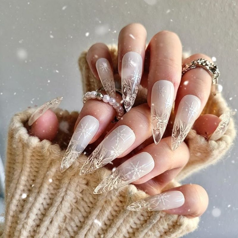 white christmas press on nails with snowflake designs being applied showing sizing and glue application tutorial
