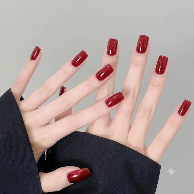 Short squared gel nails in classic red with a rounded apex and glossy finish, built to stay flexible through winter wear