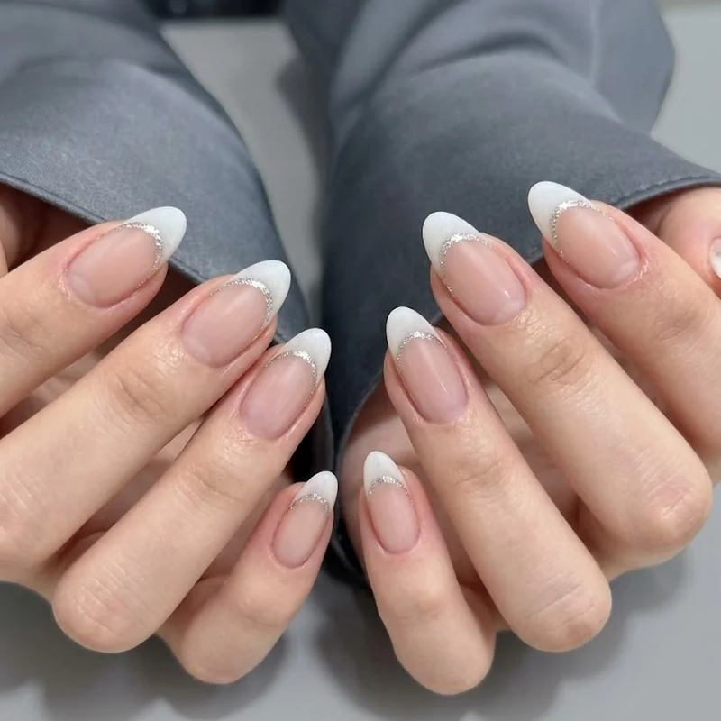 Silver and navy chrome almond winter nails with a reflective metallic finish