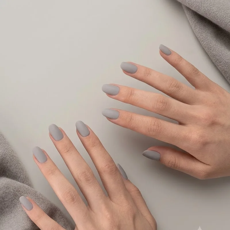 Matte dove grey winter manicure with minimalist quiet luxury styling and cashmere texture
