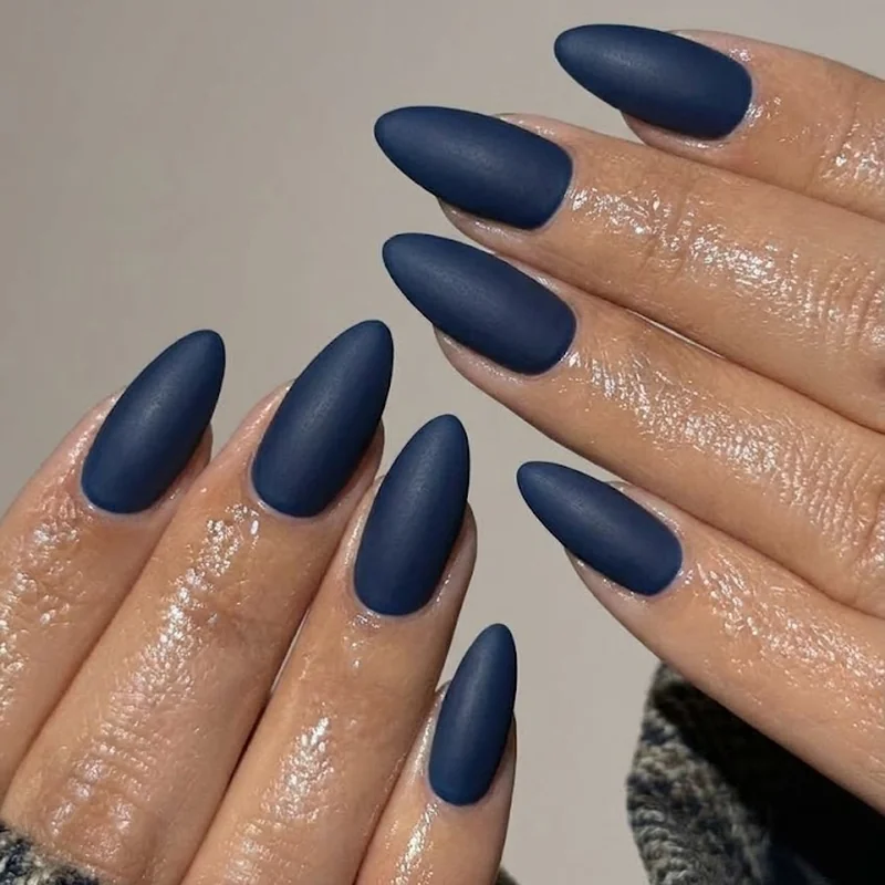 Matte navy blue winter nails with cool-toned styling against a wool coat sleeve