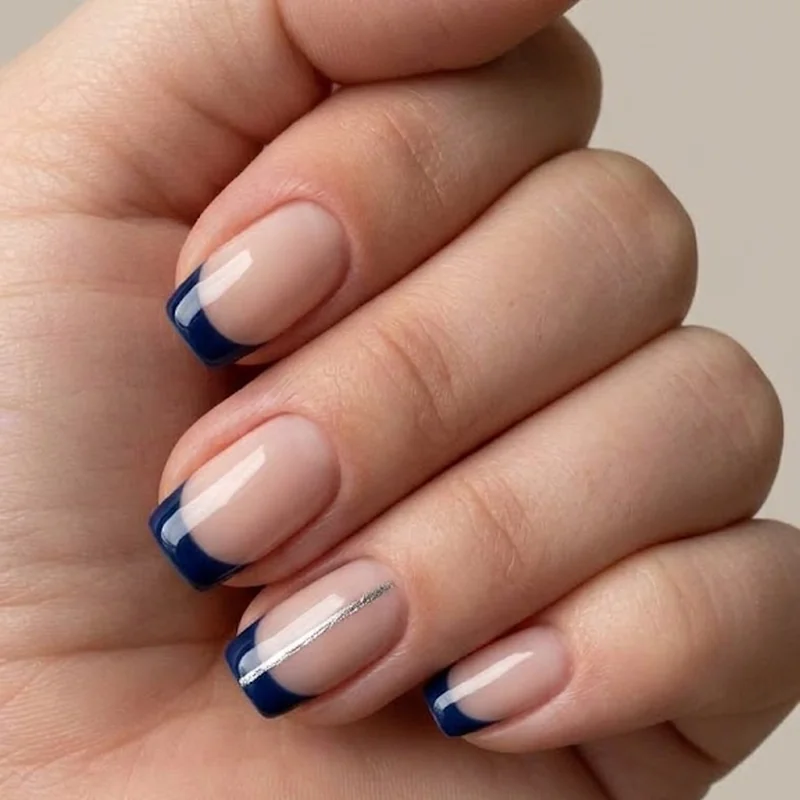 Navy blue French tip nail manicure on a nude milky base with an accent nail design