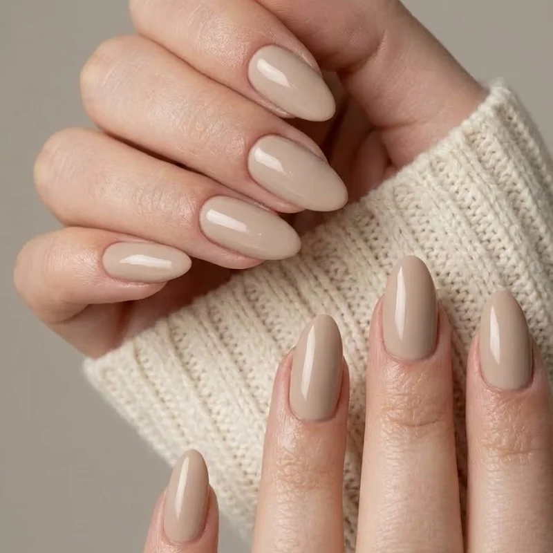 Cashmere beige old money winter nails for apres-ski, short almond shape against a cream knit sweater sleeve