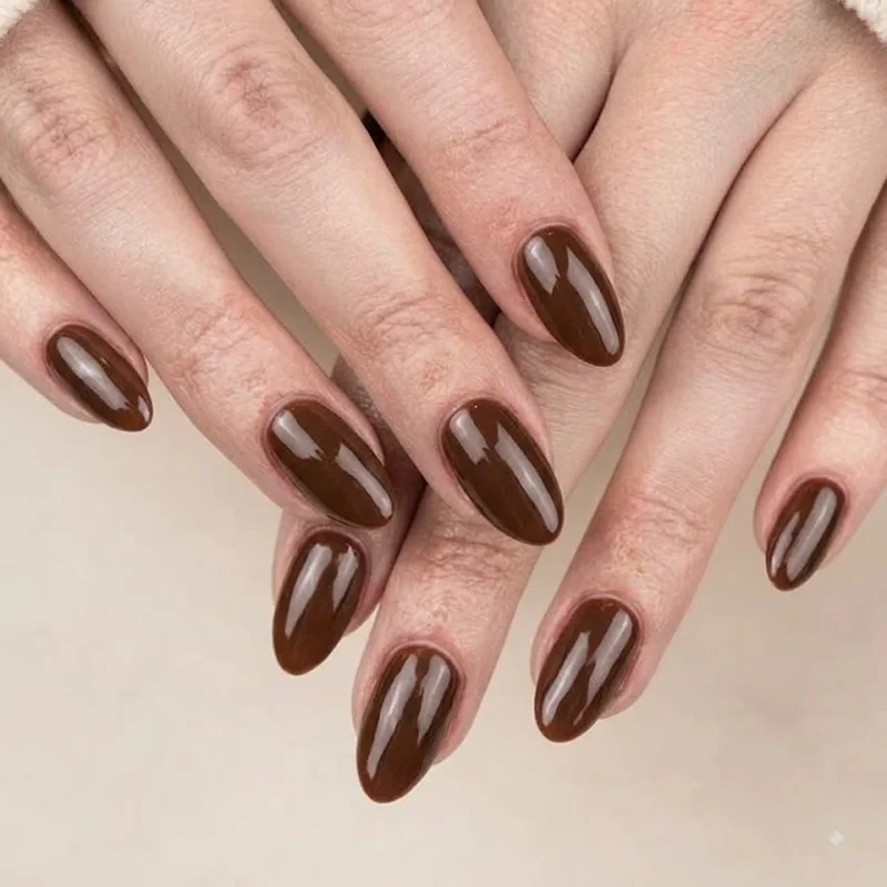 Espresso brown old money winter nails in a glossy short almond shape, styled against a cream knit sleeve
