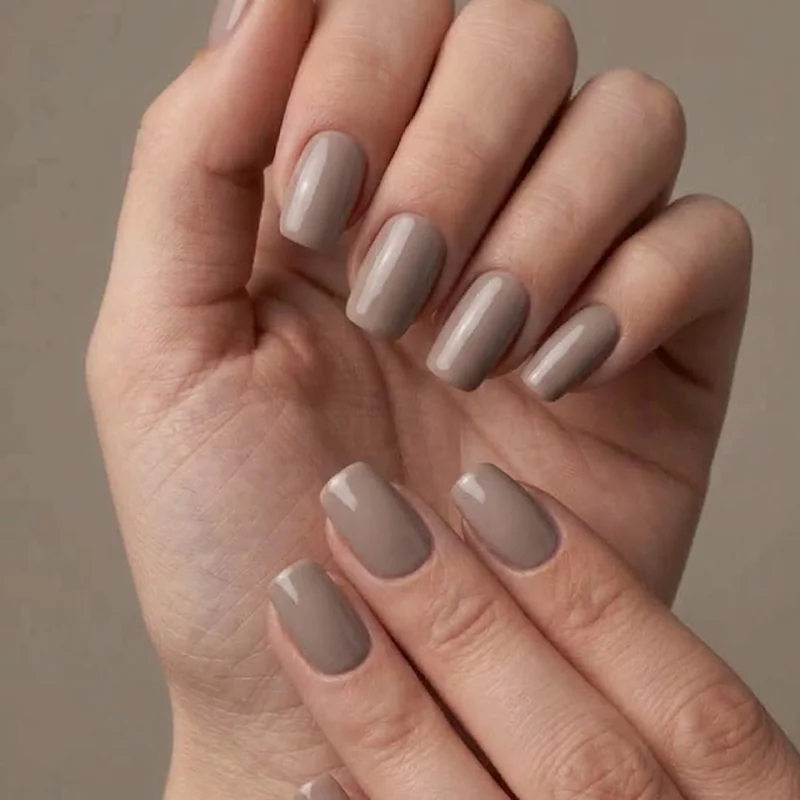 Squoval short winter nails in a neutral taupe polish, showing the clean, softened square tip shape up close and centered