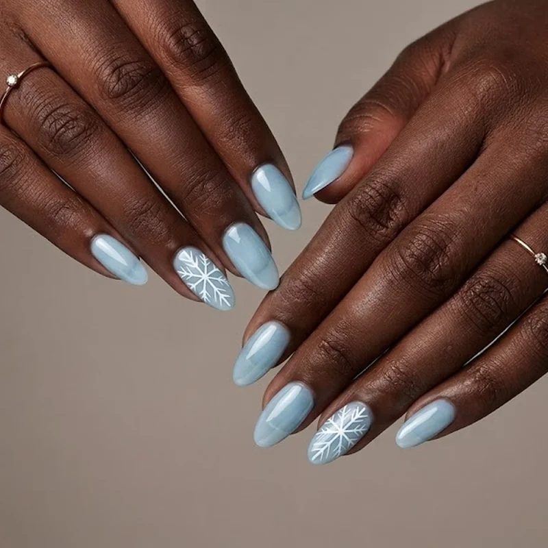 Five line freehand snowflake nail art in white polish over a pale icy blue base coat