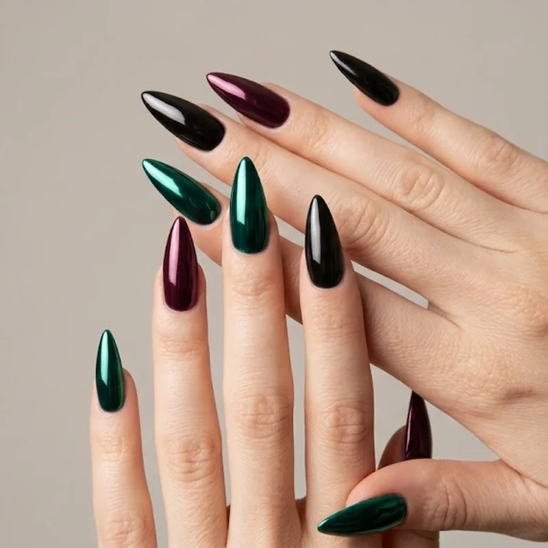 Black and burgundy jewel tone chrome nails under dramatic lighting showing deep mirror reflection