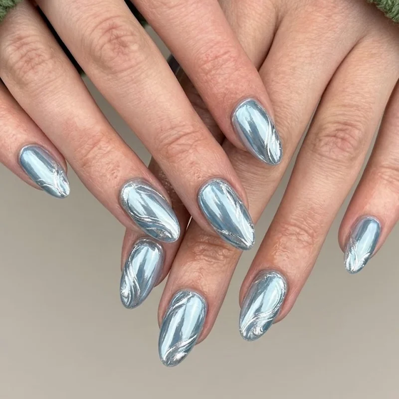Icy blue silver chrome nails on almond shape styled with a chunky knit winter sweater sleeve