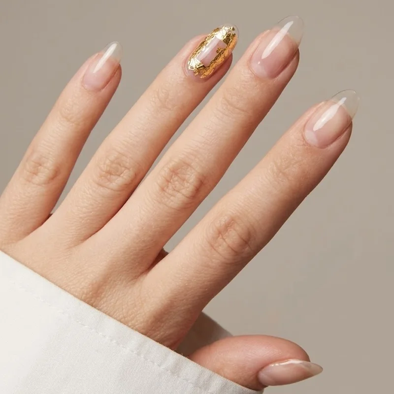 Gold foil accent nail with negative space design for winter metallic nail ideas