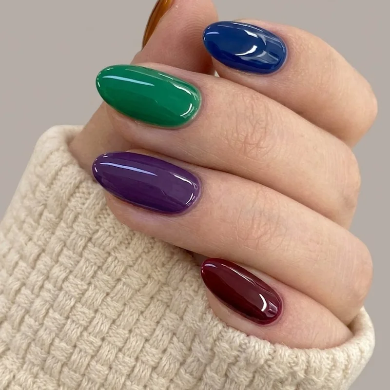 Rainbow skittle mismatched nail set in jewel tones as a bold winter nail idea